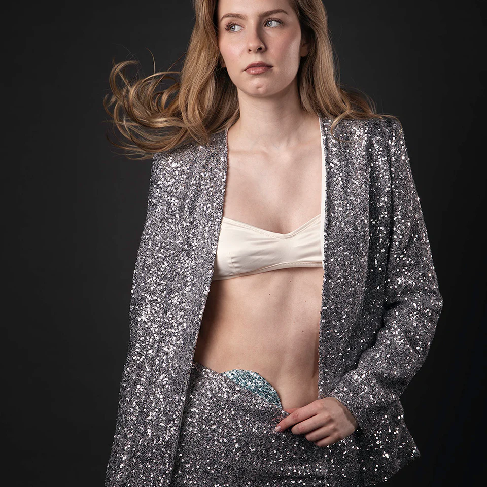 Woman wears blue sequin cover with sparkly jacket and trousers